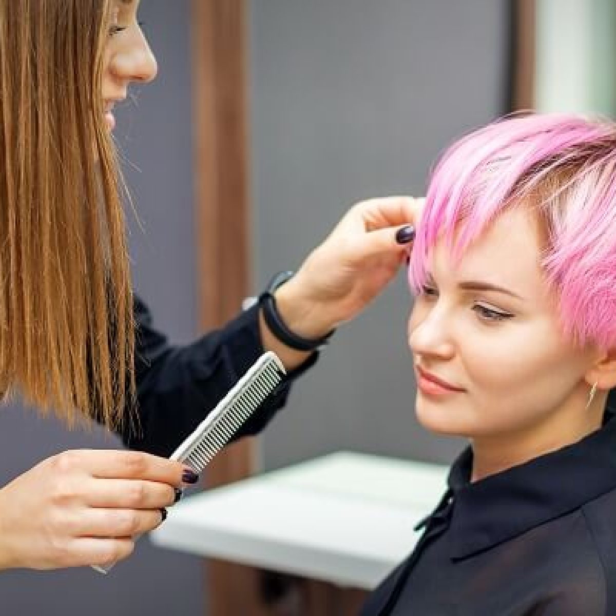 young-woman-receiving-short-pink-hairstyle-by-female-hairdresser-beauty-salon